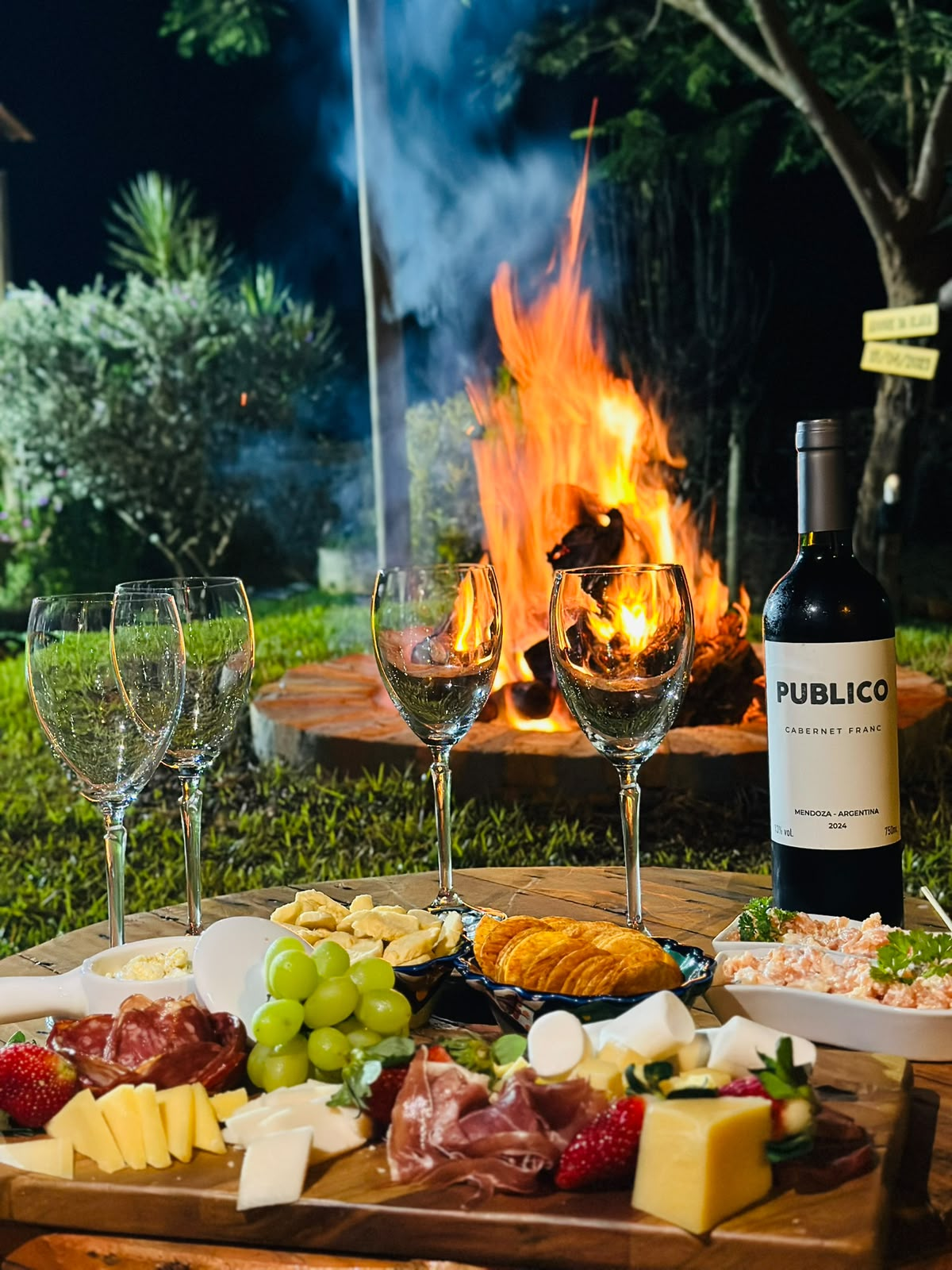 Tábua de frios e vinho em frente à fogueira